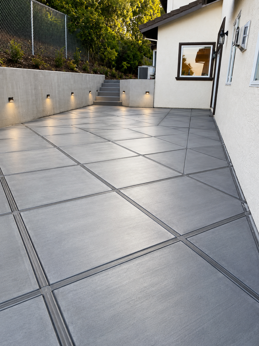 Scored concrete patio + lit retaining wall
